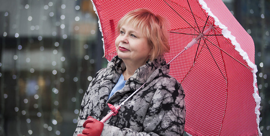 Leila Savolainen pitää punaista sateenvarjoa.