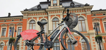 Sähköavusteinen kaupunkipyörä on parkkeerattu kaupungintalon edustalle..