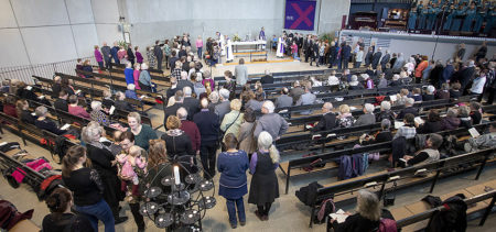 Alavan kirkon 50-vuotisjuhlamessussa kirkkosali on täynnä ja väki kulkee ehtoolliselle.