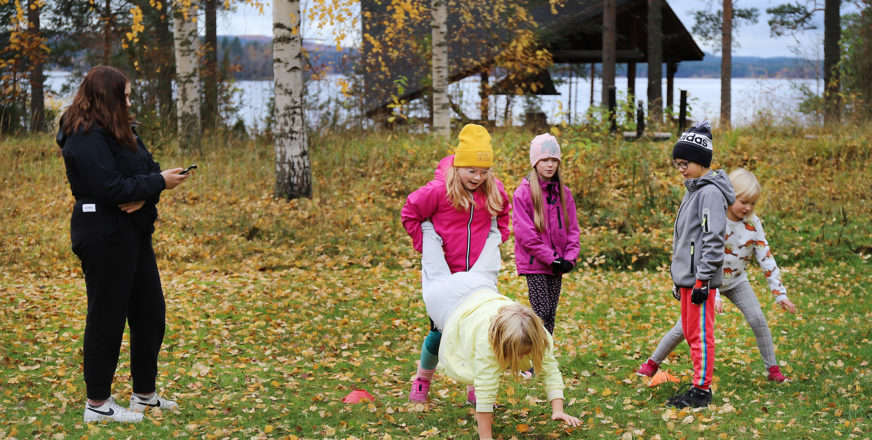 Lapsia ulkoilemassa syksyisellä pihalla.