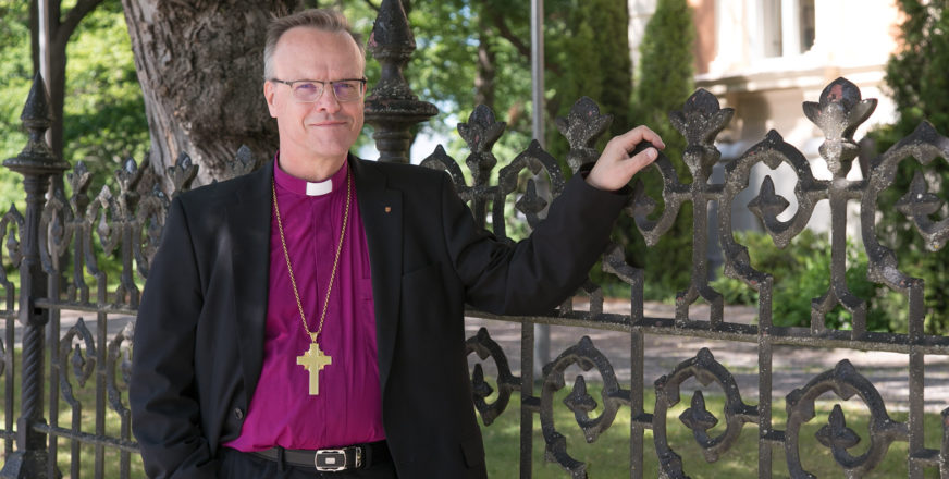 Arkkipiispa Tapio Luoma nojaa kirkon rauta-aitaan.