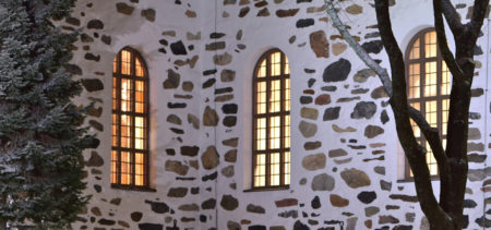 Kuopion tuomiokirkon seinää ja valaistuja ikkunoita