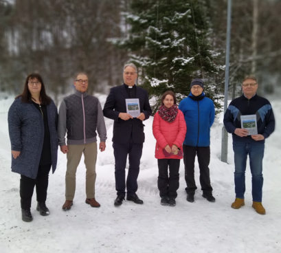 Maaningan kirkon historiikin tekijät yhteiskuvassa.