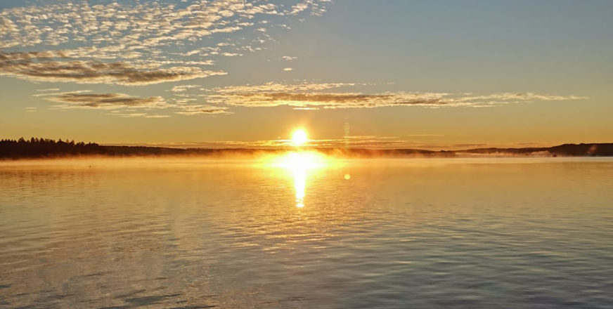 Auringonlasku järven taa.