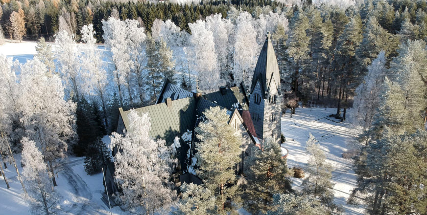 Muuruveden kirkko lumisessa maisemassa, kuvattuna dronella ylhäältä päin.