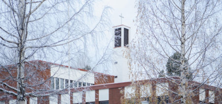 Puijon kirkon kellotorni ja lumiset puut.