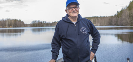 Hannu Koskelainen lenkkeilyasussa laiturilla, taustalla tyyni lammen pinta