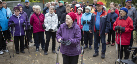 Rollaattorin kanssa eturivissä Liisa Rissanen, taustalla suuri joukko ulkoilevaa kansaa.