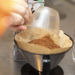 Kahvia kaadetaan suodatinpussiin kahvimitalla.