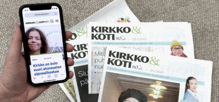 Painettuja Kirkko ja koti -lehtiä viuhkan muodossa, ja kännykässä avoimena Kirkko ja koti -verkkolehden etusivu.