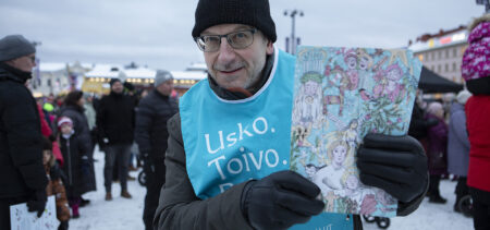 Tuomiorovasti Risto Voutilainen esittelee kameralle joulukalenteria Kuopion torilla.