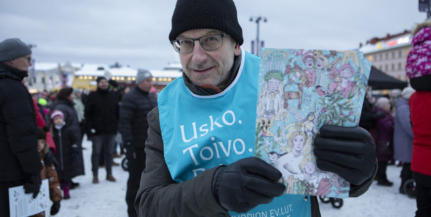 Tuomiorovasti Risto Voutilainen esittelee kameralle joulukalenteria Kuopion torilla.