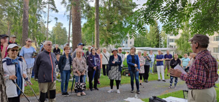 hautausmaakävely Viinamäenhautausmaalla. Ihmiset ovat kerääntyneet ohjaajan ympärille kuulemaan tarinaa