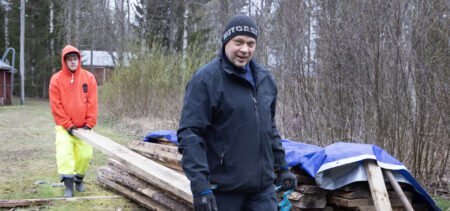 Miehet kantavat pitkospuulankkuja varastoon kuivumaan.
