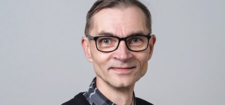 Kasvokuva Jouni Lintusesta, hymyilee hieman.