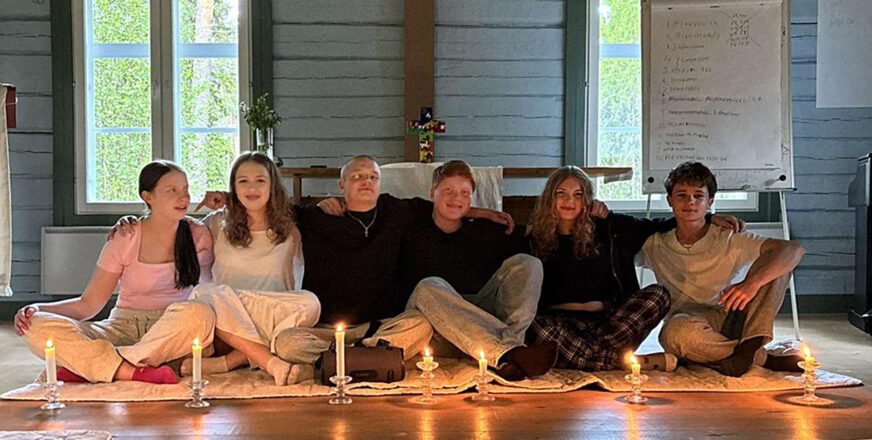 Nuoria istumassa leirikeskuksen kappelin lattialla alttarin edessä.