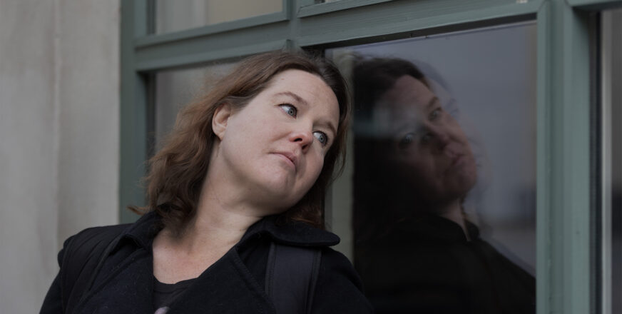 Anna Miinin nojaa päätään ikkunalasiin sivulle katsoen.