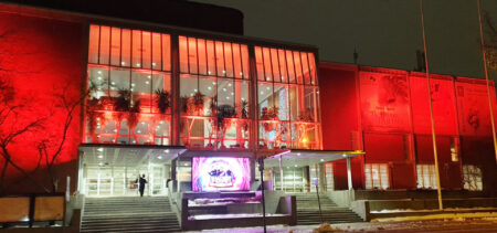 Oranssiksi valaistu rakennus, Kuopion Musiikkikeskuksen julkisivu.