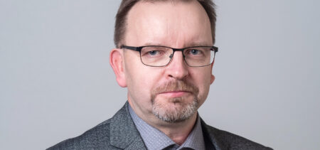 Kasvokuva Juha Nykäsestä, silmälasit ja harmaa vaatettus