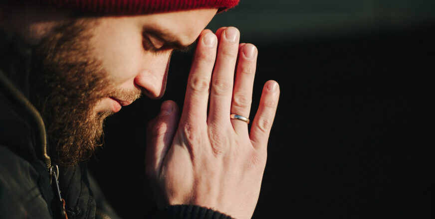 Sivuprofiili miehestä, joka rukoilee kämmenet nostettuna kasvojen eteen.