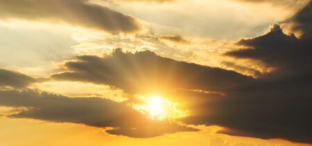 Auringonsäteet pilkistävät pilvien välistä.