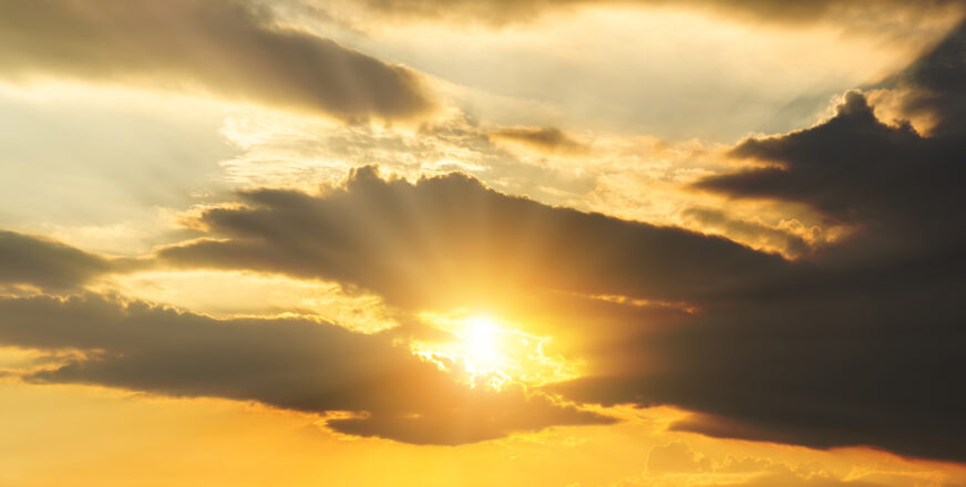 Auringonsäteet pilkistävät pilvien välistä.