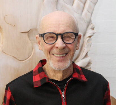 HEnkilö katsoo hymyillen kameraan.