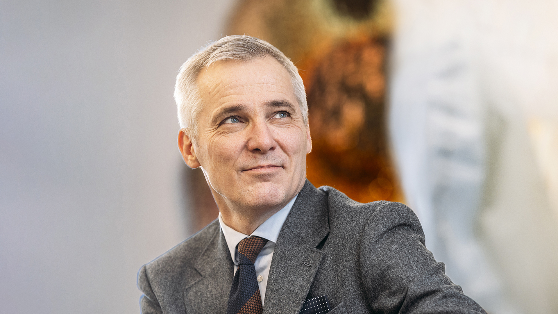 Henkilö seisoo rennosti hymyillen.