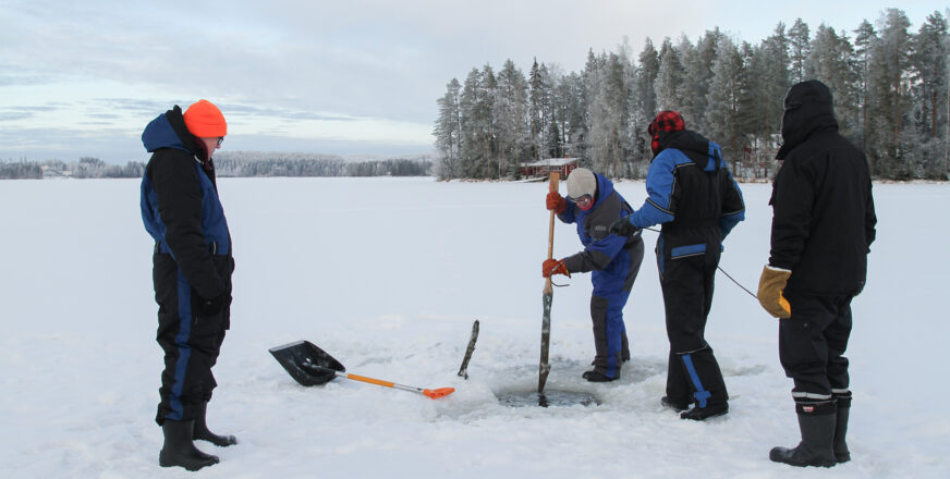 Neljä ihmistä kalastamassa järven jäällä.