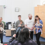 Vanhemmat ja lapset leikkivät iloisina yhdessä ringissä.