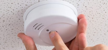 Käsi ja palovaroitin.