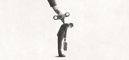 Piirroskuva henkilöstä, joka nuokkuu pystyssä väsyneenä. Selässä on mutteri, jolla voidaan vetää vieteriin lisää voimaa.