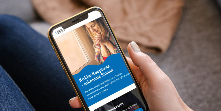 Puhelin kädessä, siinä auki Kuopion seurakuntien verkkosivut.