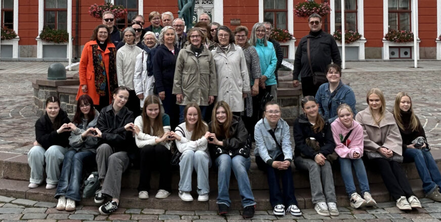 Joukko ihmisiä suihkulähteen luona aukiolla.
