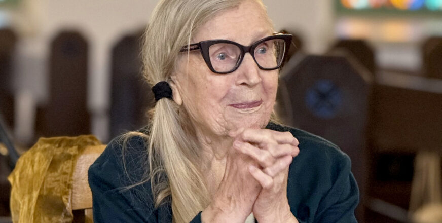 Irja Pietarinen istuu Siilinjärven kirkossa kädet ristittynä.
